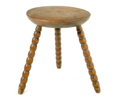 AN EARLY 20TH CENTURY FRENCH SMALL OAK BOBBIN STOOL with turned solid oak chamfered top and three bobbin leg supports.28cm di