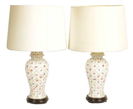 A PAIR OF LARGE PORCELAIN BALUSTER SHAPED TABLE LAMP STANDS on carved wood bases with associated shades.lamp bases 37cm highT