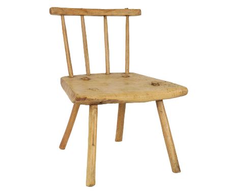 AN 18TH CENTURY WELSH ELM COMB BACK CHILD’S CHAIR with four stick back and curved top rail; on four peg legs - small traces o