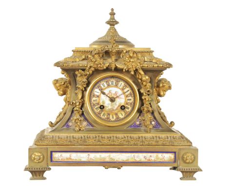 A 19TH CENTURY FRENCH PORCELAIN PANELLED ORNATE CAST BRASS MANTEL CLOCK the concave case with cherub's head side pieces, step
