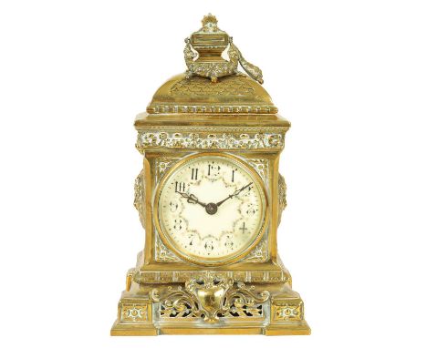 A LATE 19TH CENTURY ORNATE CAST BRASS MANTEL CLOCK the decorative case with a ribbon tied cresting above an ivorine dial with