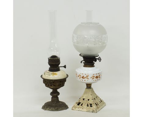 Two table oil lamps. An oil lamp with a ceramic body sitting in a metal stand, with a clear glass chimney, height including c