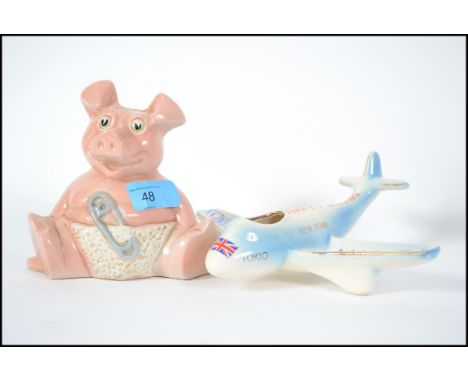 A vintage 20th century ceramic ashtray in the form of an aeroplane with destinations in lettering to the body together with a