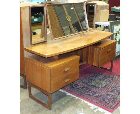 A retro G-Plan triple-mirrored light teak dressing table fitted with two drawers and a cupboard door, 152cm wide and a matchi