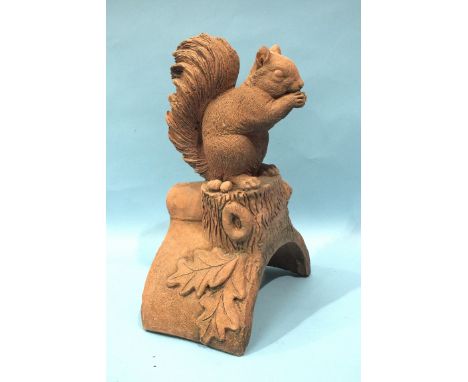 A modern terracotta roof tile ridge finial depicting a squirrel, 17cm wide 40cm high.
