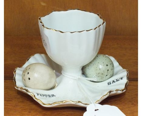 A Carltonware egg cup, 6cm high, with a salt and pepper in the form of two bird's eggs.