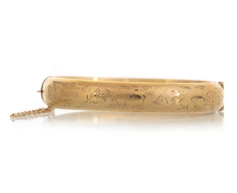 BANGLE, IN NINE CARAT GOLD  with engraved floral decorationQty: 12.4g