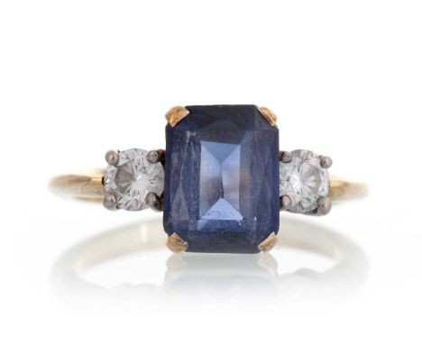 SAPPHIRE AND DIAMOND RING, set with a central step cut sapphire flanked by round brilliant cut diamonds totalling approximate