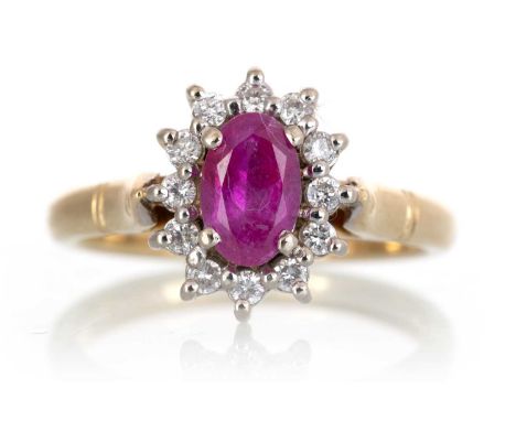 RUBY AND DIAMOND CLUSTER RING, set with a central oval ruby within a halo of small diamonds, in eighteen carat gold, size L 1
