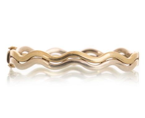 BI-COLOUR BANGLE, IN NINE CARAT GOLD in a stylised wave design6.5cm wideQty: 11.89g
