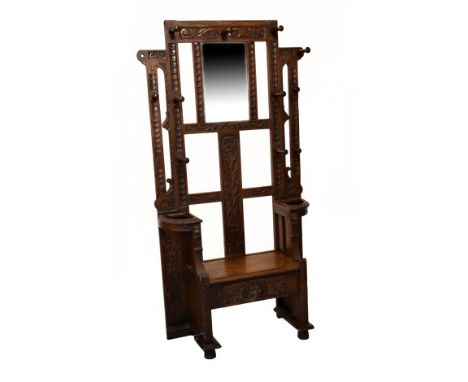 Early 20th Century carved oak hallstand with bevelled rectangular mirror framed by carved uprights and flowering plant above 