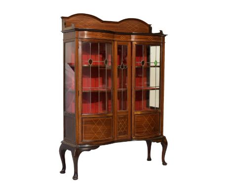 Early 20th Century inlaid mahogany display cabinet of serpentine-fronted design with double arched boxwood-strung surmount an