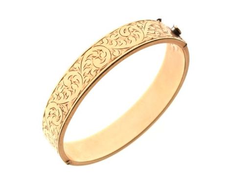 Yellow metal snap bangle with foliate scroll engraved decoration, stamped '9ct Gold Metal Core', 21.8g gross approx  