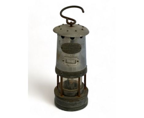 A vintage miner's oil lamp with hanging hook by E. Thomas &amp; Williams. The attached plaque on the front states 'E.Thomas &