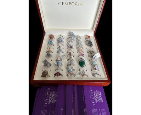 A polished wood Gemporia ring box containing 43 silver and gem set rings, many with their Gemporia tags still attached. Most 