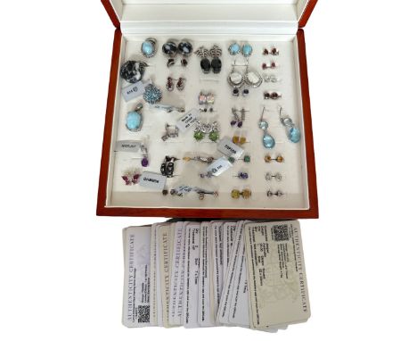 A polished wooden Gemporia box containing sterling silver earrings and pendants, many still with their original Gemporia tags