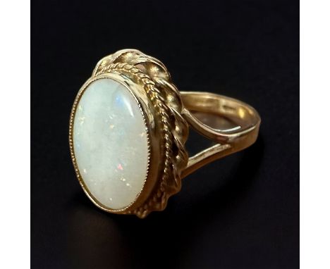 A 9ct opal ring - oval opal cabochon with gold rope twist surround, size Q. Small crack in the bottom of the opal. Opal appro