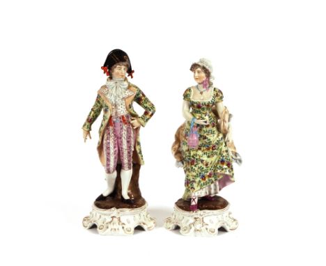 A pair of 19th Century German porcelain figures, of a lady and gallant wearing brightly coloured enamel decorated clothing ra