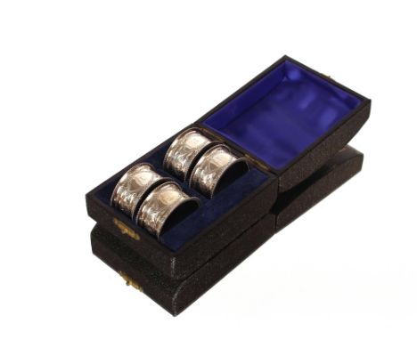 A cased set of four late Victorian silver napkin rings,&nbsp;initialled "R" with foliate decoration