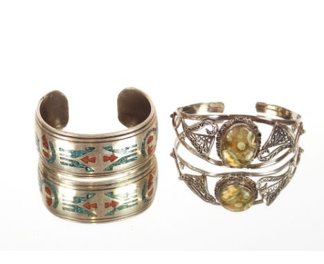 A heavy white metal and enamel decorated bangle,&nbsp;with stylised motifs; and a white metal filigree work and hardstone set