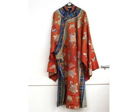 An antique Chinese Mandarin cloak, having flower, butterfly and symbol decoration on a peach ground with blue borders, gilt m