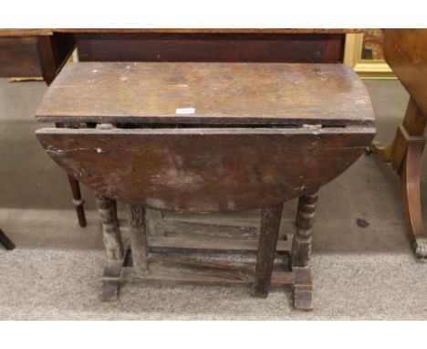 An 18th Century oak gate leg tea table,&nbsp;the rounded drop leaves raised on single end turned column supports, 75cm&nbsp;