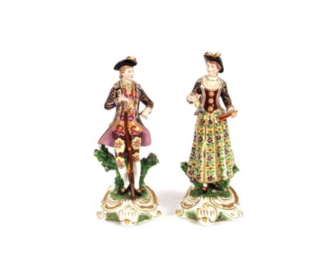 A pair of continental porcelain figures,&nbsp;depicting lady and gallant shooting, both wearing brightly coloured enamel clot