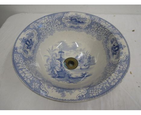 A blue and white ceramic basin with plug hole