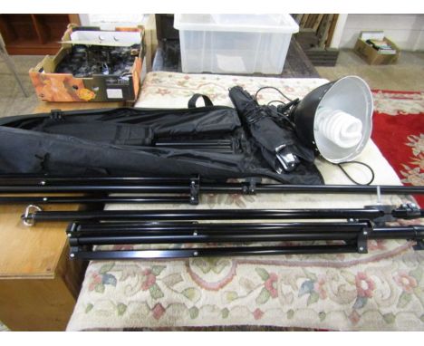 A bag with 2 large tripods and other items, a studio light with reflector