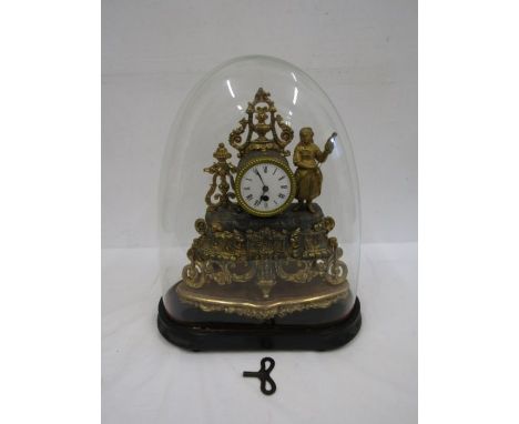 A French brass ornate clock in a glass dome with key 44cm tall from feet to top