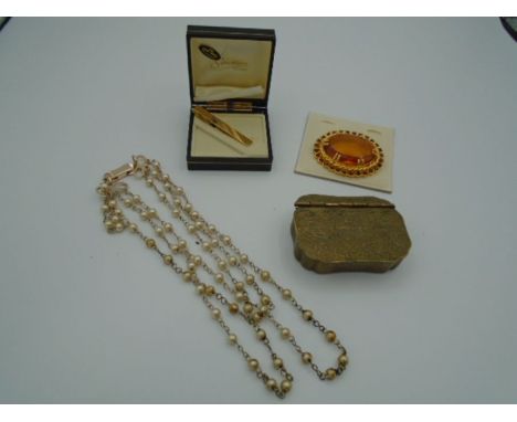 A bag of costume jewellery to include a small snuff box and a boxed tie clip by Stratton. 