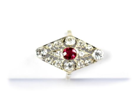 An Art Deco style 18ct white gold ruby and diamond cluster ring, the pierced lozenge head with central bezel set ruby surroun