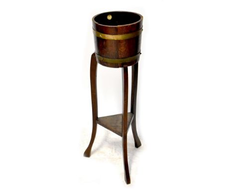 An RA Lister &amp; Co, Dursley metal bound oak planter on stand united with triangular lower shelf, height 91cm.