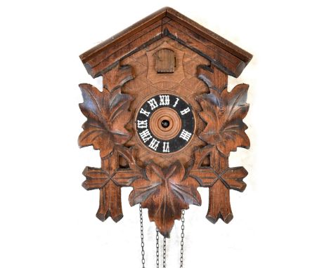 A Swiss wall-hanging cuckoo clock with carved leaf decoration, the dial set with Roman numerals, 24 x 18cm (af).