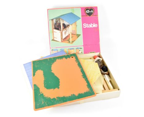 A boxed Sindy stable by Pedigree, also with pail, pony brush and comb, stable brush, riding hat and saddle.