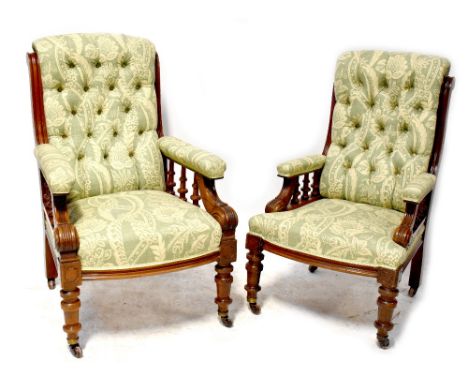 A pair of late Victorian mahogany gentlemen's armchairs with button back and seat, spindle turned gallery to arm supports, on