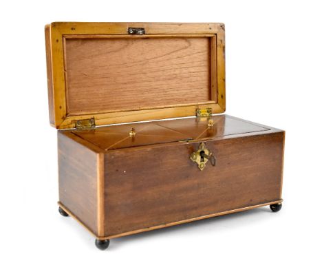 A 19th century mahogany tea caddy of rectangular form with boxwood stringing, the lid with drop handle enclosing a fitted two