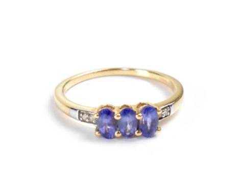 A 10ct yellow gold ladies' dress ring set with three oval blue stones and diamond chips to the shoulders, size P, approx 1.8g