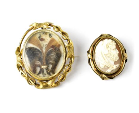A 19th century substantial mourning brooch with central swivel display depicting a plume of arranged hair and ribbon on white
