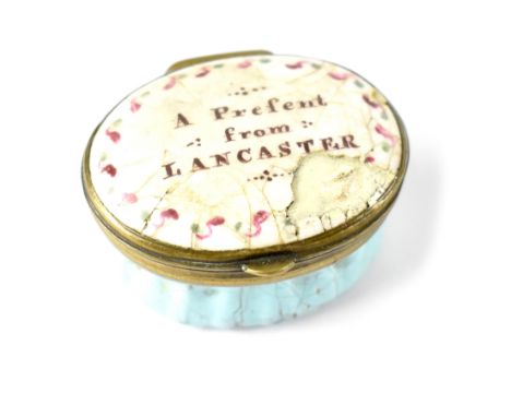 A 19th century oval enamel pill box, the lid inscribed 'A Present from Lancaster', mirror to the underside of the lid and whi