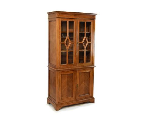 Beech cabinet bookcase, the upper section fitted three shelves enclosed by a pair of glazed doors, each having decorative tra