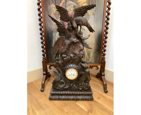 A late 19th Century oversized Black Forest clock with French pendulum movement. 36" high x 18 1/2" wide, case ornately carved