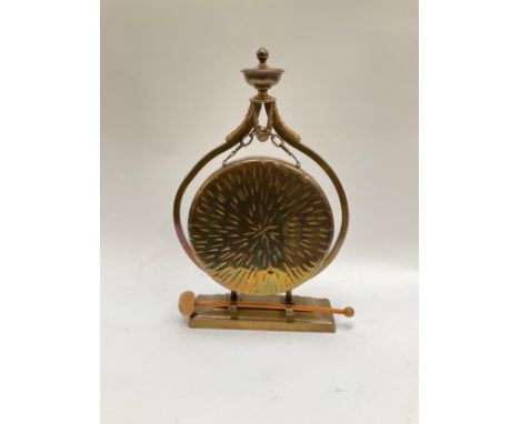 A late Victorian brass table dinner gong with finial decoration including hammer, 20cm diameter 