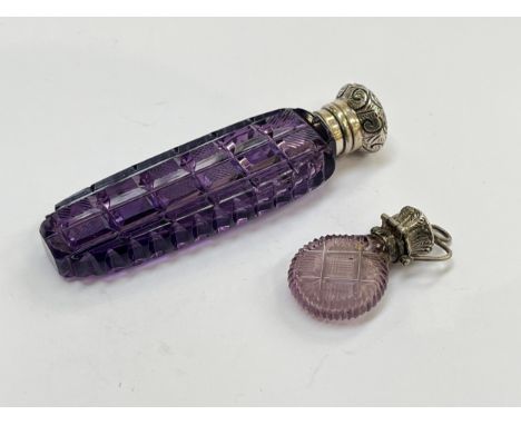 An amethyst glass scent bottle with rectangular cut panelled sides, white metal embossed lid, together with a miniature ameth