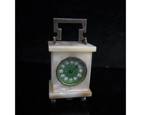 A miniature mother of pearl carriage time piece "Brevet 33812", with green guilloche enamel face and silver handle, 4.5cm tal