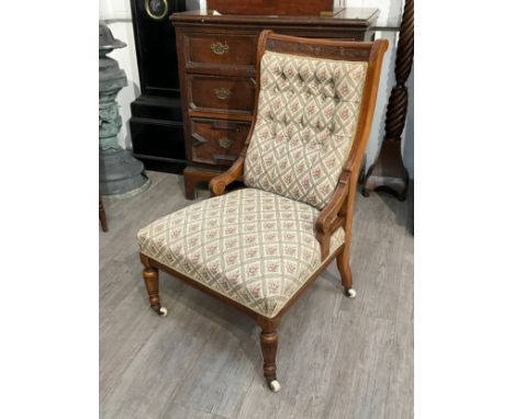 In the manner of Gillows of Lancaster a circa 1890 mahogany button back armchair with carved foliate and reeded decoration on