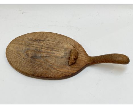 A Robert Thompson (Mouseman) oak cheeseboard with carved mouse detail to surface, 38cm length including handle x 18cm wide 