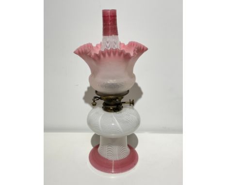 A 19th Century Hinks safety oil lamp with Nailsea opaque and pink tube-lined glass reservoir/foot and chimney, with shaded op