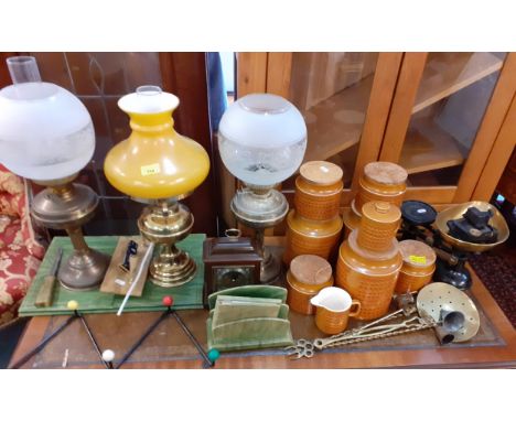 A vintage lot to include three brass oil lamps, one converted to electricity, a desk set, Hornsea Saffron kitchen cannisters,