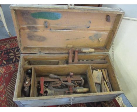 A selection of vintage hand tools contained in a tool chest to include chisels, woodworking planes and others 